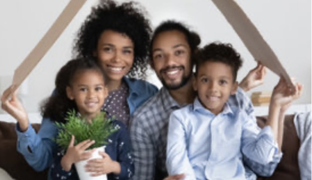 Happy family of four smiling together in their home